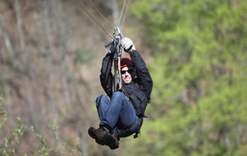 A close up of a man zip lining over Colorado's Royal Gorge near Happy Acres RV Park in Pueblo Colorado